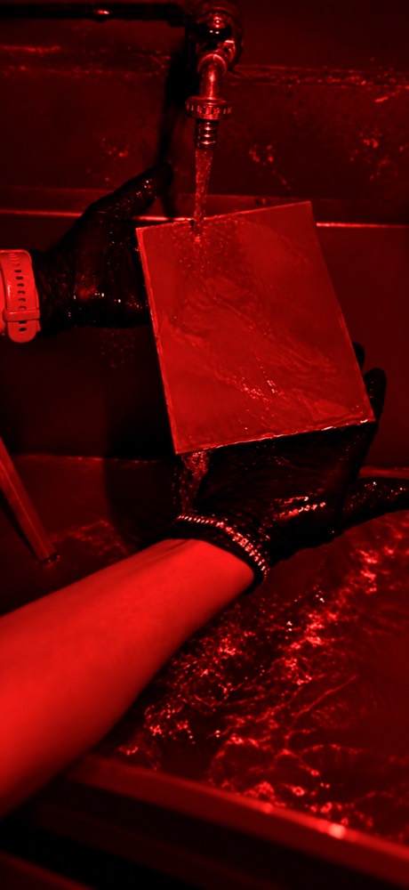 Placa de colodión bajo la luz roja del cuarto oscuro