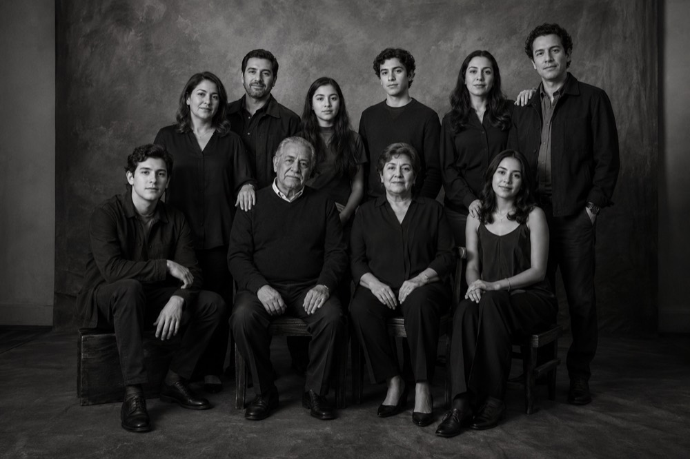 Grupo formal de diez personas en estudio, en blanco y negro