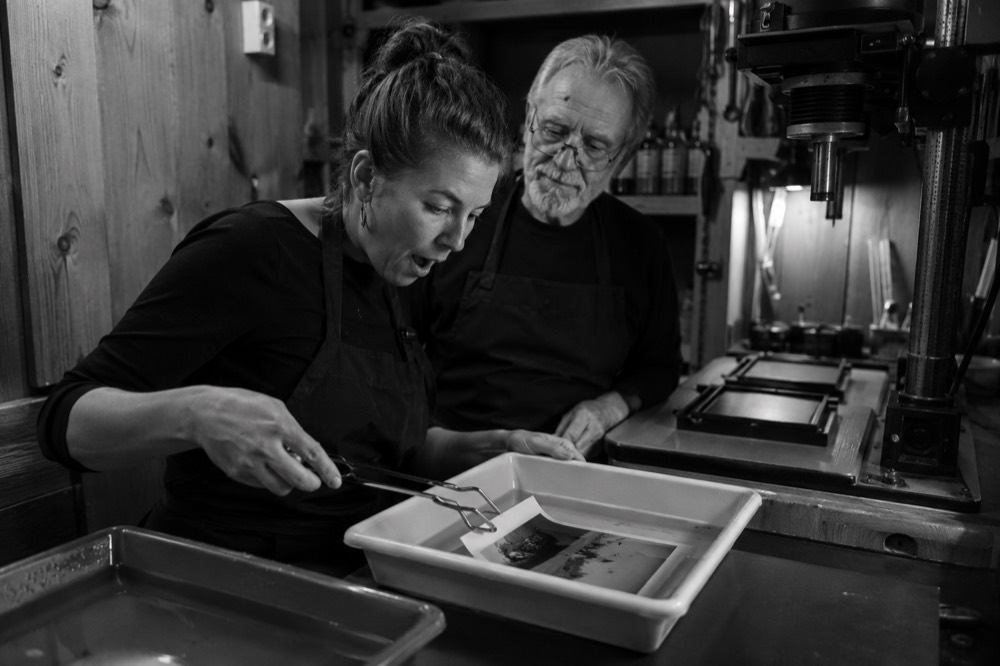 Dos personas trabajando en el cuarto oscuro, en blanco y negro